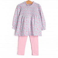 This set features a pink floral print, ruffle trim around the neck, and elastic smocking across the chest. Coordinating pink leggings to match.