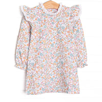  This dress features a blue floral print, eyelet lace trim, and long sleeves. 