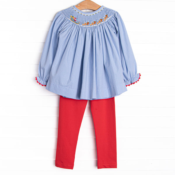This set features a blue gingham print, red picot trim, and a santa sleigh smocking. Coordinating red leggings to match.