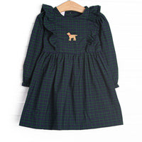 This dress features navy and green plaid, ruffle trim, and puppy embroidery. 
