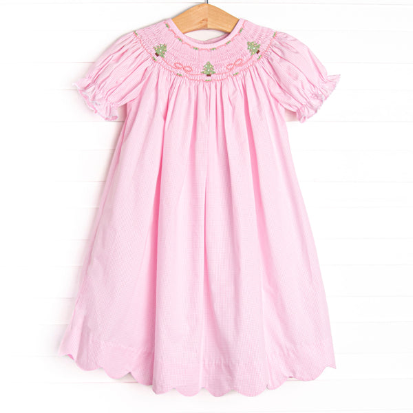 This dress features a pink gingham print, puff sleeves, and a trio of Christmas tree smockings. 