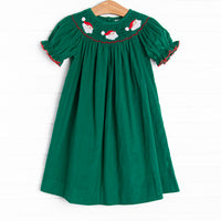  This dress features a green corduroy material, puff sleeves with red picot trim, and Santa Claus smockings