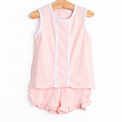  This set features a pink knit material, white trim, and ruffle shorts to match. 