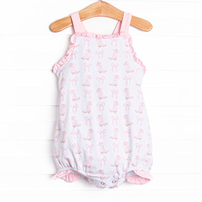 This bubble features a pink cowgirl boots print, pink ruffle trim and pink bow back. 