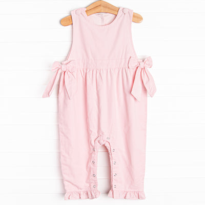  Featured in a soft pink color, with bow details on the sides and snaps along the stride. 