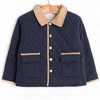  This coat features a navy quilted material, tan collar and trim, and tan gingham lining. 