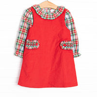  This dress&nbsp;features&nbsp;a top in a red plaid print with a ruffle collar and a red jumper dress with smocked tabs on the sides. 