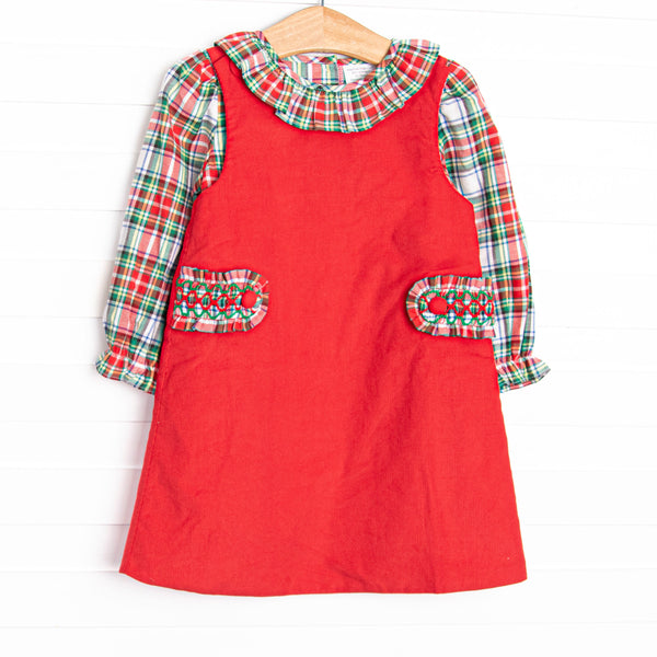  This dress&nbsp;features&nbsp;a top in a red plaid print with a ruffle collar and a red jumper dress with smocked tabs on the sides. 