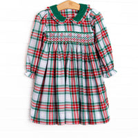 This dress features a plaid print, a green peter pan collar and dainty smocking.