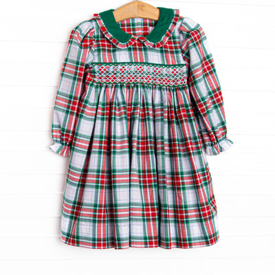 This dress features a plaid print, a green peter pan collar and dainty smocking.