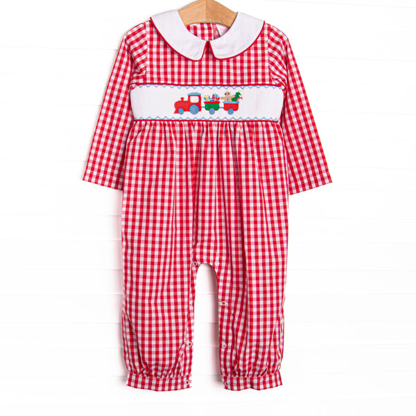  This romper features a red check print, peter pan collar, and festive train smocking. 