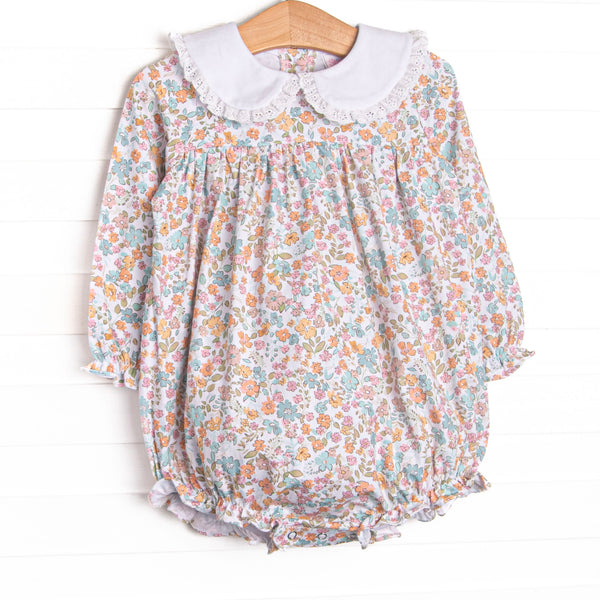 This bubble features a blue floral print, eyelet lace trim, and a white Peter Pan collar. 