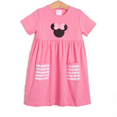  A bright pop of pink, coupled with pink and white striped pockets has us ready for a magical adventure. A mouse ears applique with a whimsical polka dot bow adorns the front of this dress. 