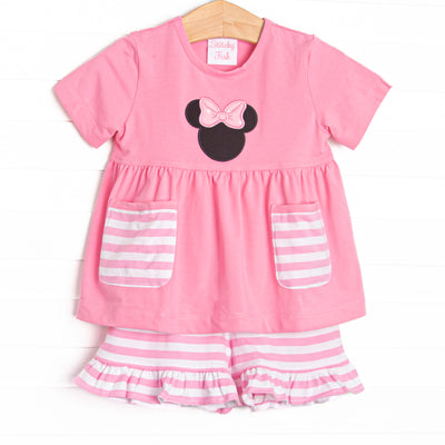 A bright pop of pink, coupled with pink and white striped pockets has us ready for a magical adventure. A mouse ears applique with a whimsical polka dot bow adorns the front of this set. Coordinating striped ruffle shorts to match.