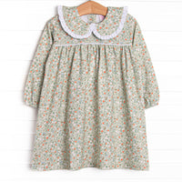 This dress features a green floral print, a peter pan collar with white ruffle trim, and the softest knit material.