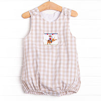  This bubble features a tan check print, a cowboy smocking, and snaps on the stride. 