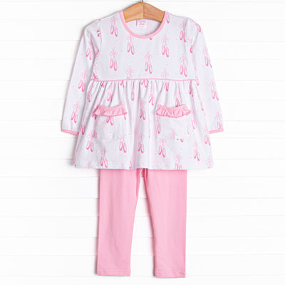 This set features a ballet slipper print, ruffle trim, and pink leggings to match.