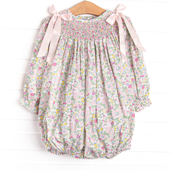  A long sleeve bubble with a pink smocking and pink bow details on the shoulders. 