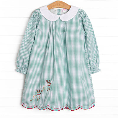 This dress features a green gingham print, a peter pan collar, and reindeer embroidery.