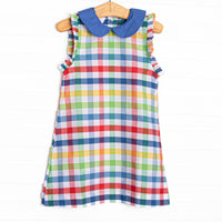 This dress features a&nbsp; primary color check print, a blue peter pan collar and ruffle trim