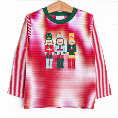 This top features a red striped print, green trim, and a trio of toy soldiers applique.
