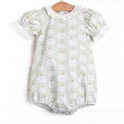 This bubble features a green pumpkin print, a ruffle collar, and snaps on the stride.