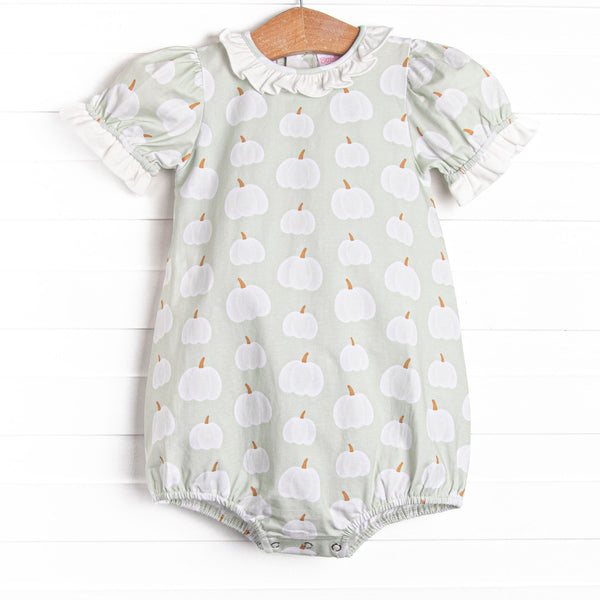 This bubble features a green pumpkin print, a ruffle collar, and snaps on the stride.
