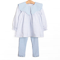 This set features a blue gingham print, a blue scalloped bib collar, and long sleeves. Coordinating blue leggings to match.