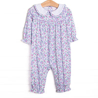 This romper&nbsp;features a lavender floral print, a peter pan collar with ruffle trim, and snaps on the stride.