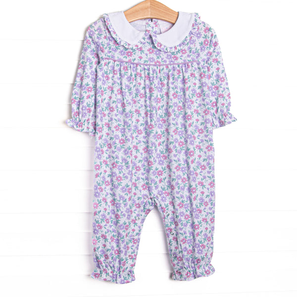 This romper&nbsp;features a lavender floral print, a peter pan collar with ruffle trim, and snaps on the stride.