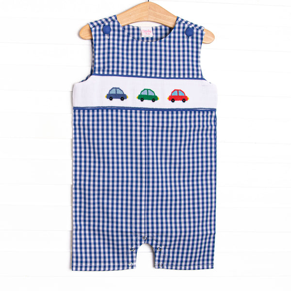 This jon jon features a royal blue gingham. snaps on the stride, and trio of cars smockings.