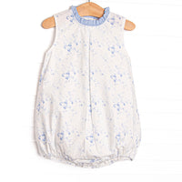 This bubble features a blue floral print, blue ruffle trim, and&nbsp; blue snaps on the stride.