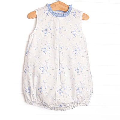This bubble features a blue floral print, blue ruffle trim, and&nbsp; blue snaps on the stride.