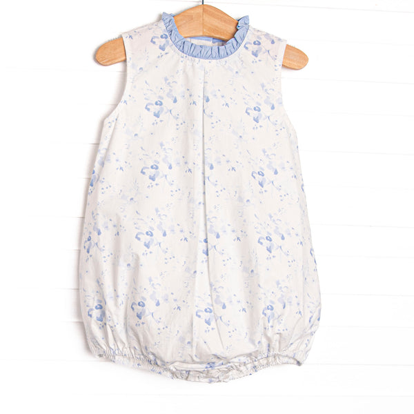 This bubble features a blue floral print, blue ruffle trim, and&nbsp; blue snaps on the stride.