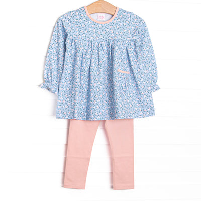 This set features a blue floral print, a pink ruffle neck, and a front pocket. Coordinating pink leggings to match.