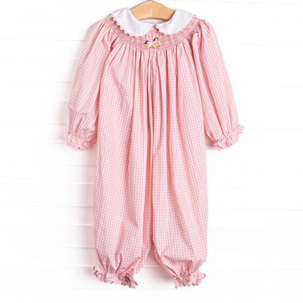 This romper features a pink gingham print, a peter pan collar with ric rac trim, and a rocking horse smocking.