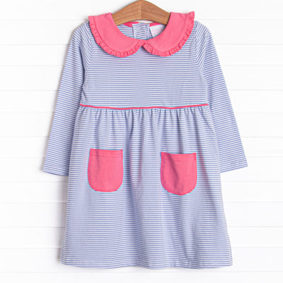 This dress features periwinkle stripes, front pockets, and a peter pan collar with ruffle trim.
