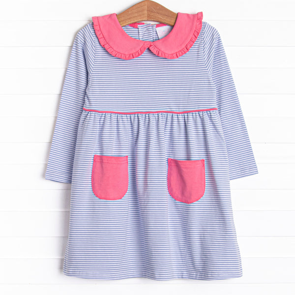 This dress features periwinkle stripes, front pockets, and a peter pan collar with ruffle trim.