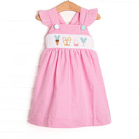 This dress features a pink gingham print, flutter sleeves, and a magical treat smocking.