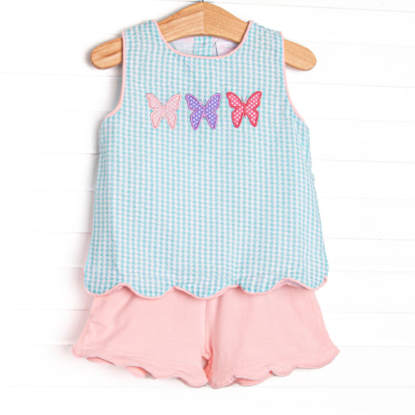  This set features an mint green gingham print, a trio of butterfly applique, and pink scalloped shorts to match. 
