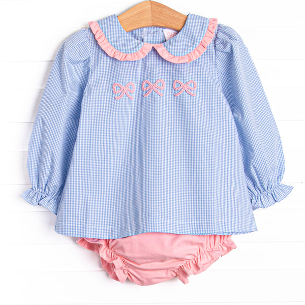 This set features a blue gingham print, a peter pan collar with pink ruffle trim, and a trio of bow embroideries. Coordinating pink diaper cover to match