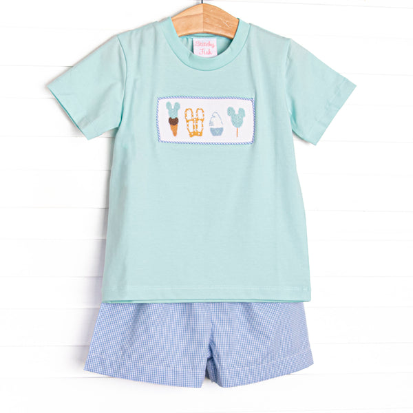 This set features a mint green short sleeve top with a magical treat smocking and blue gingham print shorts.