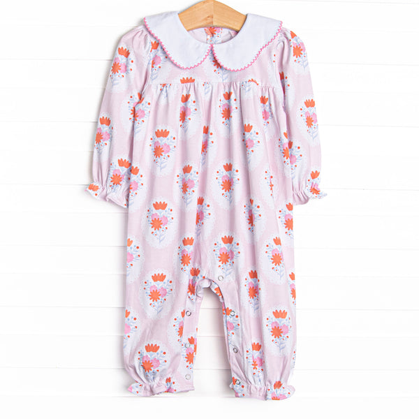 This romper features a pink floral print, a scalloped collar, and snaps on the stride.