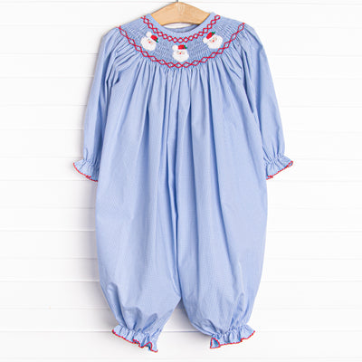 This romper features a blue mini gingham print, red picot trim and a Santa Claus smocking.