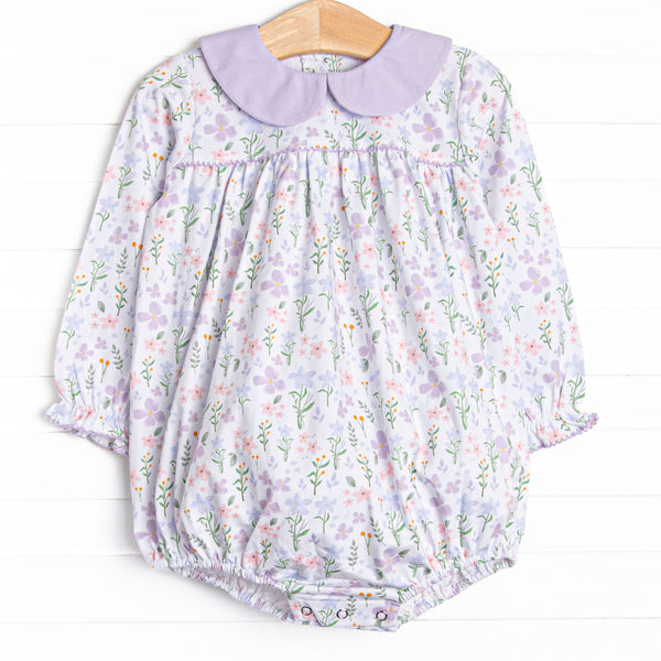 This bubble&nbsp; features a purple floral print, a purple peter pan collar and snaps on the stride to make changing a breeze.