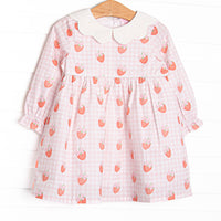 This dress features pink gingham and strawberry printed fabric, a white scalloped collar, and long sleeves.
