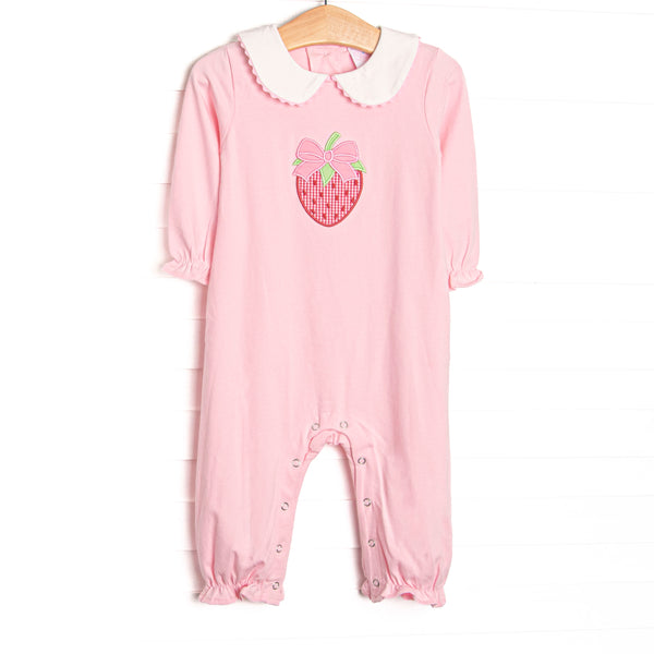 his romper features pink knit fabric, a white Peter Pan collar, strawberry and bow appliques, and snaps along the stride to make changing a breeze