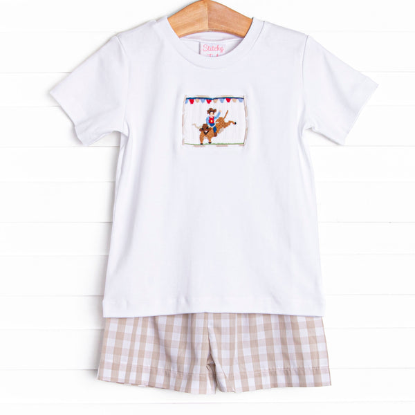This set features a shorts sleeve top with a cowboy smocking and tan check shorts to match.