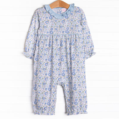 This romper features a blue floral print, a blue ruffle collar, and snaps on the stride.
