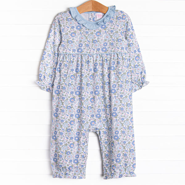 This romper features a blue floral print, a blue ruffle collar, and snaps on the stride.